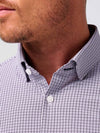 Close-up of a person wearing a checkered shirt with a blurred background